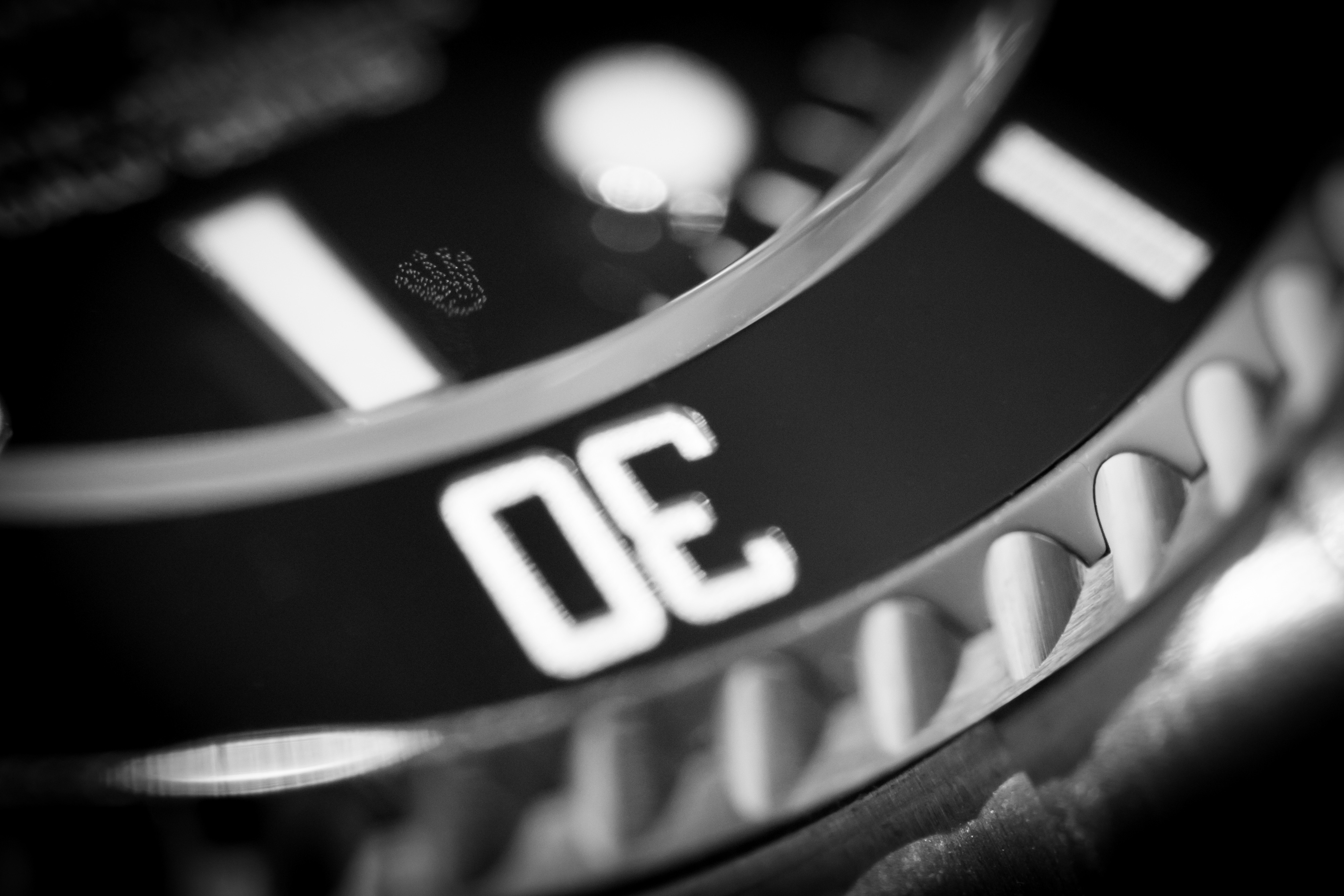 Dettaglio in bianco e nero della lunetta e della lente Cyclope del Rolex Submariner Date 116610LN